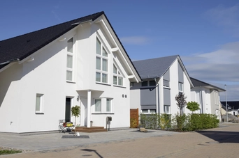 Einfamilienhaus Siedlung Weiße, neue Einfamilienhäuser nebeneinander. Die Sonne scheint