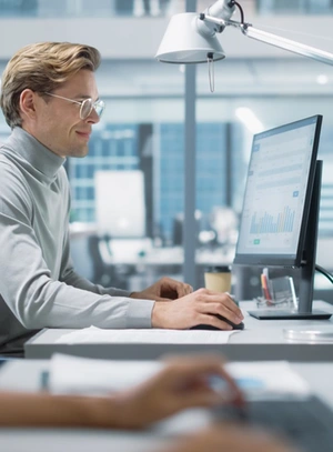 Mann vor dem PC sitzend.