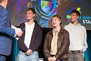 Finalisten Band Motion Mitglieder der Band Motion sprechen auf der Bühne mit dem Moderator Ingo Börchers über ihr Kulturprojekt.