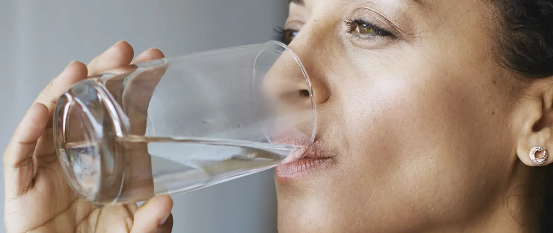 Frau trinkt Wasser aus einem Glas
