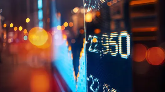 Stromhandel an der Strombörse Eine digitale Anzeige zeigt Börsenkurse und Marktdaten in einer nächtlichen Stadtumgebung.