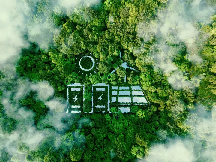 Zukunftsgebiet Energiespeicherung Eine Luftaufnahme zeigt Wald mit Symbolen für Solarenergie und Batteriespeicher zwischen den Bäumen.