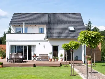 Einfamilienhaus Gartensicht Ein modernes Einfamilienhaus vom Garten aus fotografiert mit einer großen Terrasse
