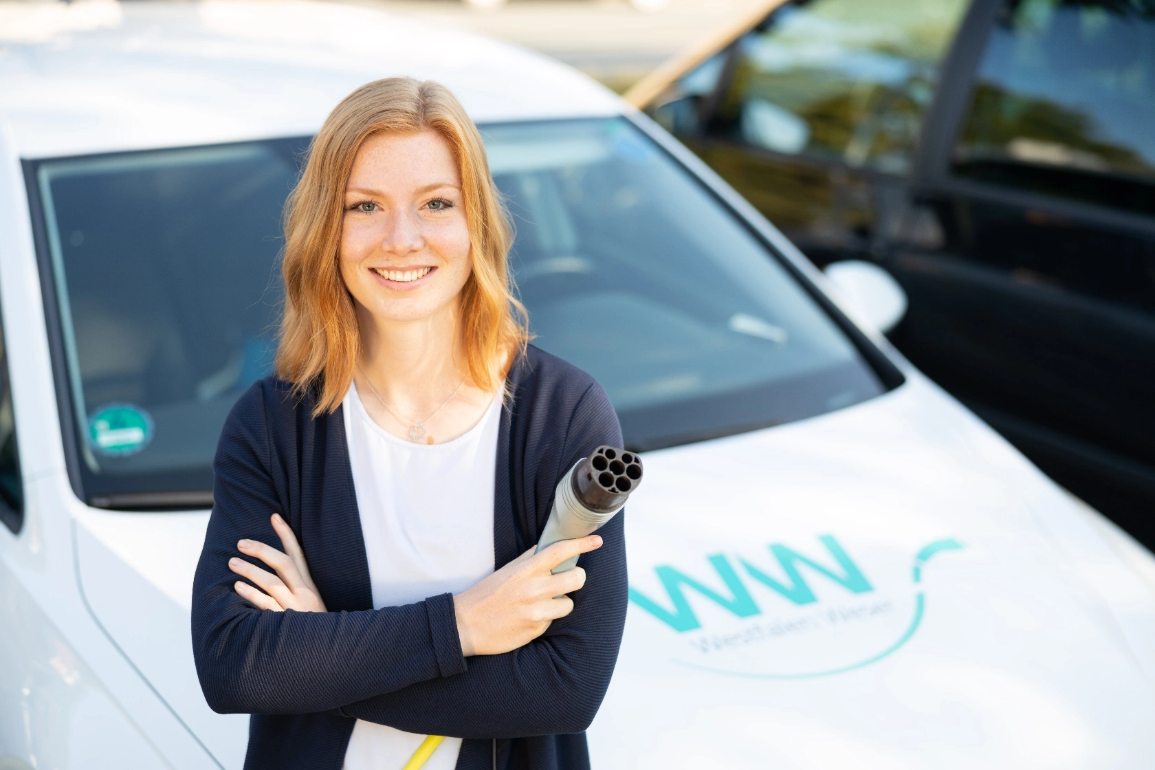 Frau beim Aufladen mit Stecker für Elektroauto Westfalen Weser