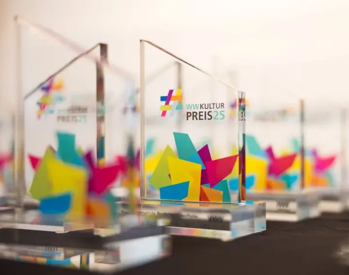 WWKulturpreis Preise Preisverleihung Mehrere Preise des WWKulturPreises stehen auf einem schwarzen Tisch. Die Preise sind aus Plexiglas und mit dem WWKulturpreis Logo versehen