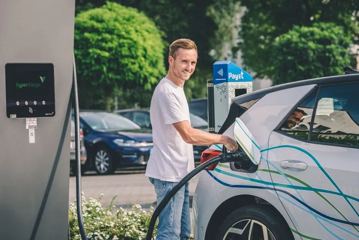 Schnellladesäule im Alltag Ein Mann lädt ein Elektroauto an einer Schnelladesäule