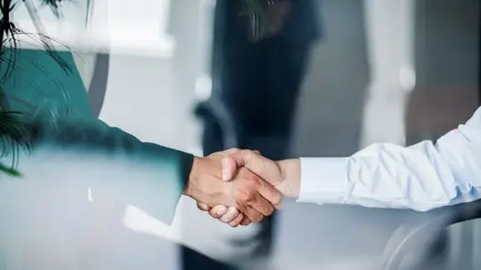 Händeschütteln Zwei Personen die Hände schütteln. Das Foto wurde durch eine Glasscheibe gemacht