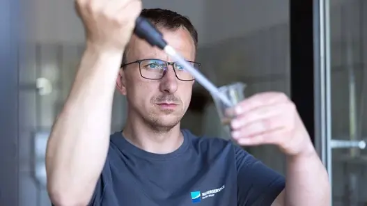 Mann analysiert eine Wasserprobe.