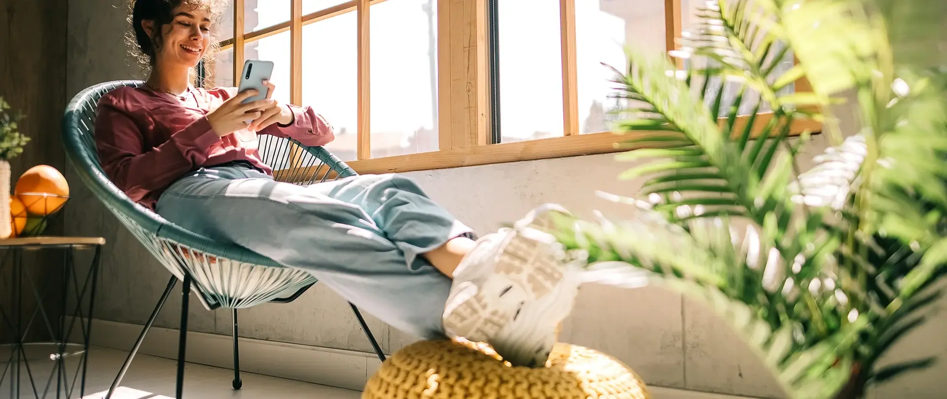 Frau sitzt am Fenster und genießt Wärme