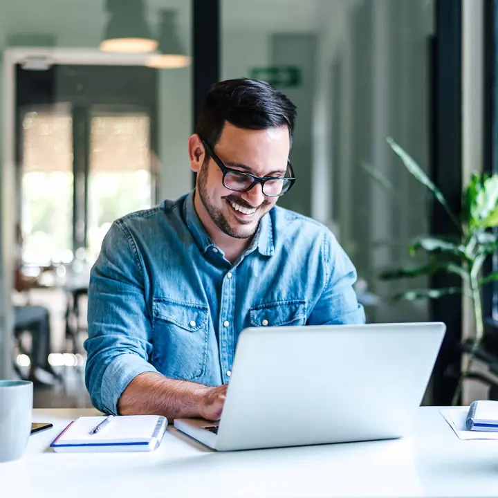 Flexibles IT-Backendsystem für E-Mobilitätslösungen Eine Person arbeitet am Laptop in einem modernen Büro – für digitale Steuerung von Ladeinfrastruktur.